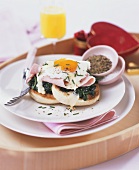 English muffin topped with spinach, ham and fried egg