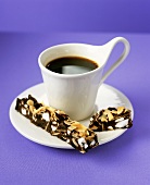 Baiser-Schokoladen-Kuchen und Mandelblätten und Tasse Kaffee