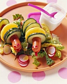 Frankfurter, potato and cucumber snakes with salad