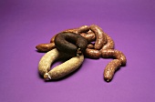 Various types of sausages on purple background