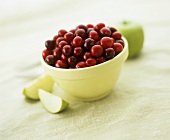 Fresh cranberries in a bowl and green apple wedges