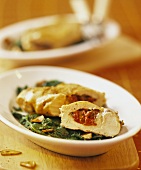 Stuffed chicken breast on a bed of spinach leaves