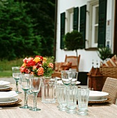 A table laid outside with a bunch of roses