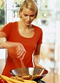A young woman cooking with a wok