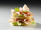 Slices of bread topped with salami and lettuce