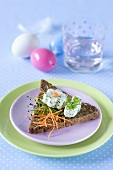 A piece of wholemeal toast topped with herb cream cheese and raw vegetables for Easter