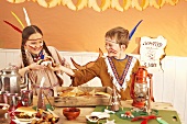 Two children dressed as Indians fighting over a hamburger at a party