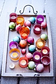 Christmas tree baubles and tea lights in a tray