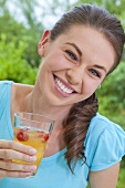 A girl holding a glass of orangeade