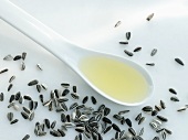 A spoonful of sunflower oil surrounded by sunflower seeds
