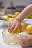 Child's hand squeezing a lemon