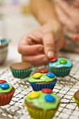 Decorating chocolate cupcakes with chocolate beans