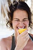 Woman biting into a lemon (and pulling a face)