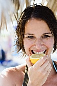 Woman biting into a lemon