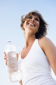 Junge Frau mit einer Wasserflasche im Freien