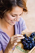 Woman eating black grapes
