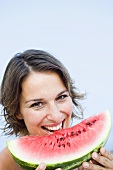 Junge Frau isst ein Stück Wassermelone