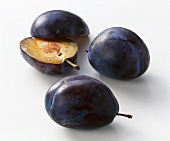 Two whole and one halved plum (variety: Bluefree)