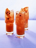 Three pomegranate drinks with slices of blood orange