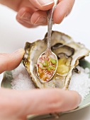 Hand sprinkling fresh oyster with sauce