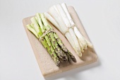 A bundle of white and a bundle of green asparagus, peeled