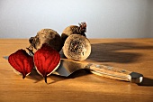 Three whole and one halved beetroot with a knife