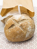 Two rye rolls in front of a brown paper bag