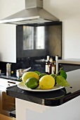 Lemons and limes on plate in kitchen