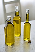 Three bottles of olive oil on wooden table