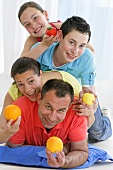 Fröhliche Familie hält frisches Obst und Tomate