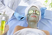Woman in face mask having cosmetic treatment
