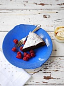 Chocolate tart dusted with icing sugar with fresh raspberries