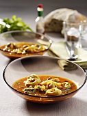 Tortellini soup in two glass dishes