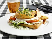Fish cake on ciabatta with potato wedges, glass of beer