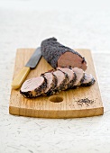 Pork fillet with poppy seed crust on chopping board