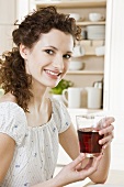 Young woman drinking red fruit juice