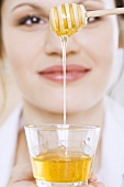 Young woman with honey and honey dipper