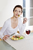 Young woman eating pork steak with boiled potatoes