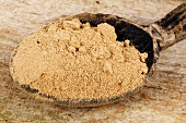 Amchur (mango powder) in wooden spoon