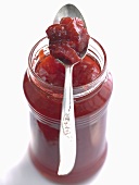 Strawberry and rhubarb jam in jar with spoon