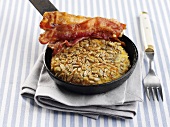 Potato pancake in frying pan with crispy bacon (Sweden)