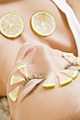 Woman with lime slices on her face and neckline