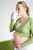 Schwangere Frau trinkt ein Glas Milch