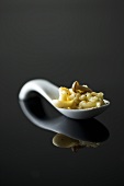 A spoonful of mushroom risotto on a reflective surface