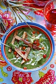 Coriander soup with strips of fried bacon