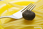 Black truffle (Chinese truffle) and fork on spaghetti