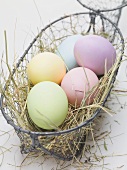 Easter eggs on hay in wire basket