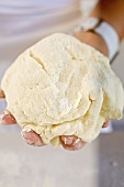 Hand holding a ball of pasta dough