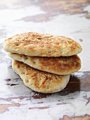 Three Turkish flatbreads on rustic table