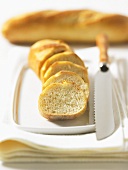 Whole and sliced baguettes with bread knife